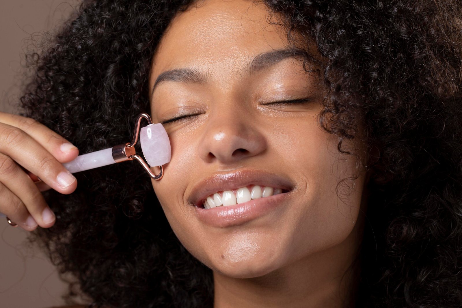 Woman using a jade roller on her face